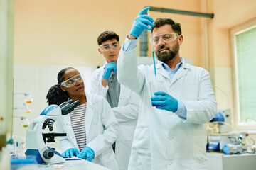 Pharmacy professor and his students working with test samples during scientific research in...