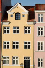 Fototapeta na wymiar Yellow historic terraced house in Nyhavn in the center of Copenhagen in Denmark