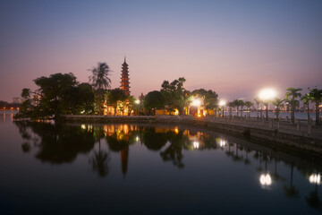 Fototapeta premium West lake and water reflection of illuminated Tran Quoc Pagoda - the oldest Buddhist temple in Hanoi at twilight, Vietnam..
