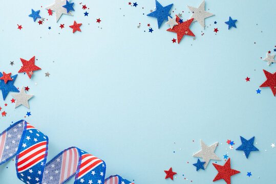 Festive elements for a patriotic celebration: curly ribbon, glittering stars, and confetti. A top view arrangement on a pastel blue background with an empty circle for text or advertisements
