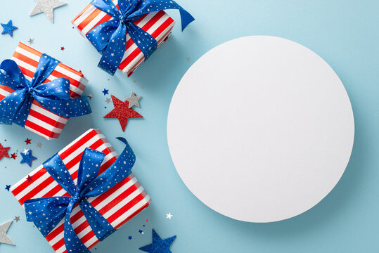 Festive party elements in a top view arrangement: shimmering confetti, sparkling stars, gift boxes in American flag wrapping, set against a blue backdrop with a blank circle for text or ad