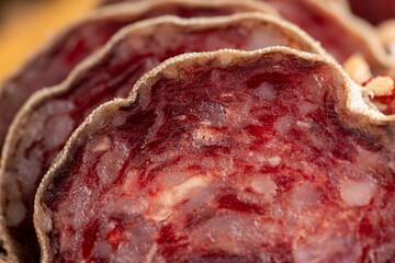 Obraz premium Sausage cut into pieces on the table