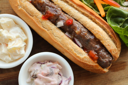 Boerewors roll with chutney and salads. Potato salad and coleslaw 