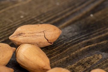 cracked unpeeled pecans close-up on the table