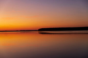 Fototapeta na wymiar beautiful orange-yellow sunset on the lake in spring