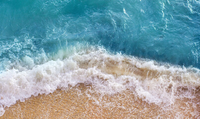 Sea with surf on the beach on a sunny summer day, top view