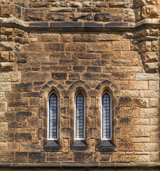 Fototapeta na wymiar Ornate windows on stone church steeple
