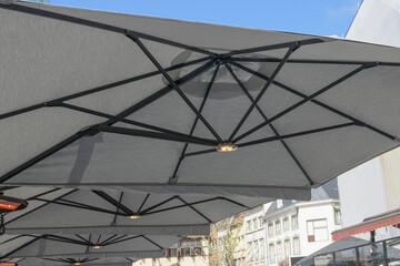 Large umbrellas - a parasol from the sun, with internal illumination installed in a cafe in the city