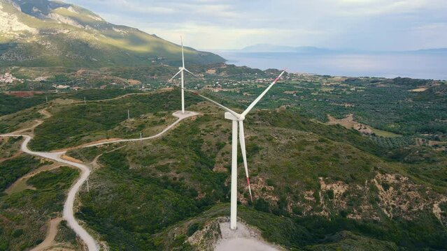Wind turbines stays idle in windless conditions in wind power farm, aerial wide shot
