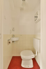 Fototapeta na wymiar a small bathroom with a toilet and red rug on the floor in front of the toilet is an open door