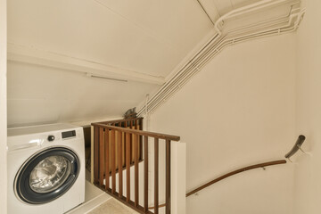 a laundry room with a washer and dryer next to the stairs in front of the washing machine on the...
