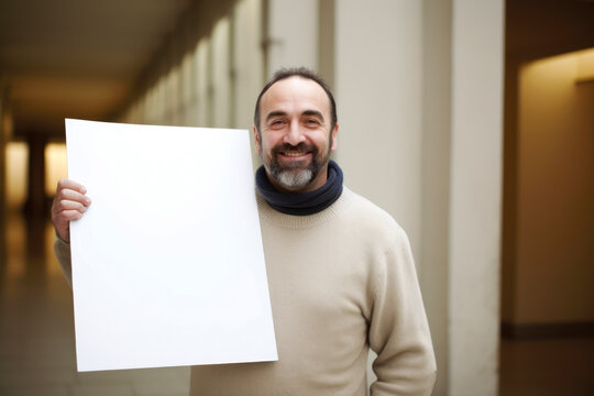 Portrait of a smiling middle-aged man holding a blank sheet of paper
