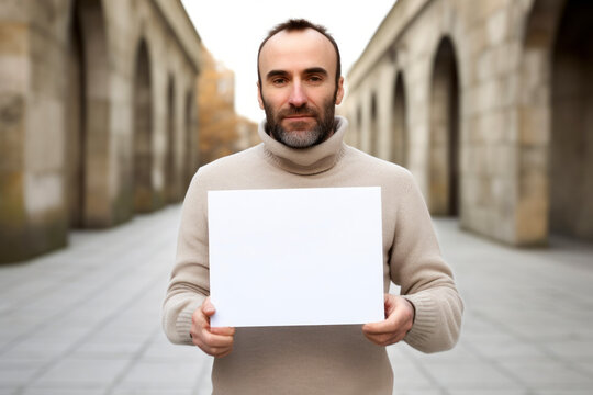 man holding blank sheet of paper in the street, shallow depth of field