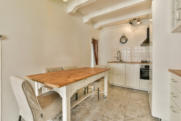 a kitchen area with a table and chairs in the corner, next to an oven on the right hand side