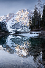 panorama sul lago di braies ancora ghiacciato all'alba, con la croda del becco sullo sfondo