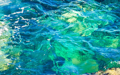 Fototapeta na wymiar Surfer waves turquoise blue water rocks cliffs boulders Puerto Escondido.