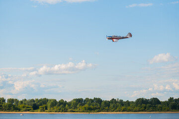Small retro airplane, light aircraft flying in blue sky at Air Show. Performance, extreme, aerobatic and sport concept