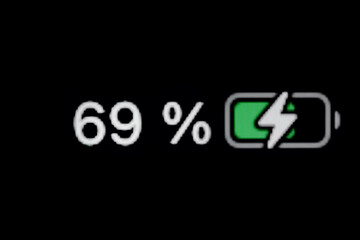 Smartphone charged battery level indicator - charging process - sixty-nine, 69 percent: close up macro view of gadget display, screen. Energy, technology, power, digital and symbol concept