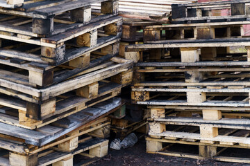 Old wooden pallets stacked on the ground.