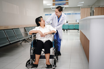Fototapeta na wymiar Shot of a doctor or nurse caring for a senior woman in a wheelchair in a hospital.