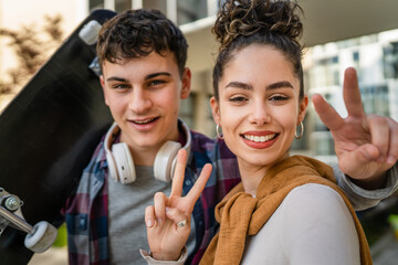 Young man and woman teenager couple take selfies by modern building