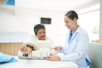 Female doctor doctor measuring senior female's blood pressure at medical clinic.