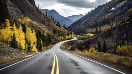 Fototapeta na wymiar A Black Asphalt Road Leading into The Mountains During Autumn