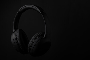 Fototapeta na wymiar Black headphones on a black background