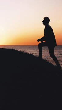 The man climbing the mountain up near the sea