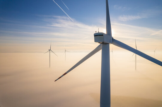 Aerial view of windfarm during winter foggy morning
