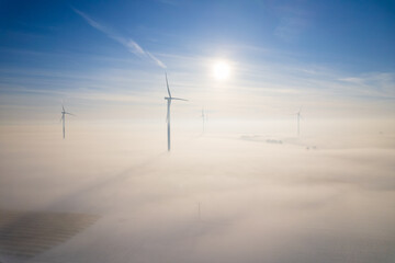 Aerial view of windfarm during winter foggy morning
