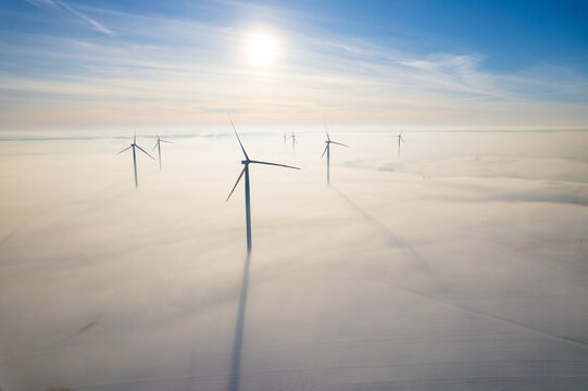 Aerial view of windfarm during winter foggy morning

