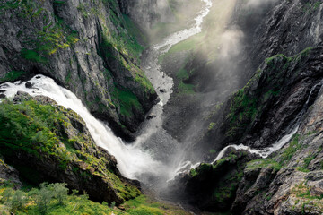 Amazing sunbeams passing through the mist created by the Voringfossen  waterfalls, Norway