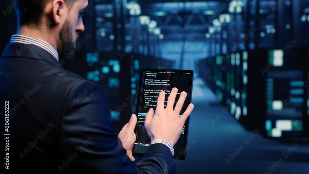 Poster support specialist checking server computers on tablet, planning mainframe system backup in server r