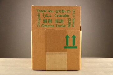 A cardboard box with green inscriptions "Thank you" in different languages