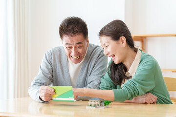 Obraz premium 通帳を見て微笑むシニア夫婦
