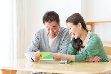 Obraz premium 通帳を見て微笑むシニア夫婦
