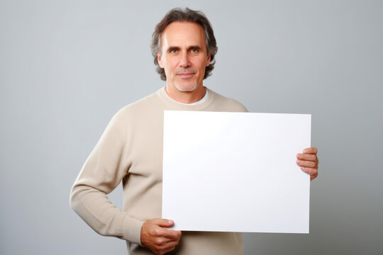 Handsome middle-aged man holding a blank sheet of paper