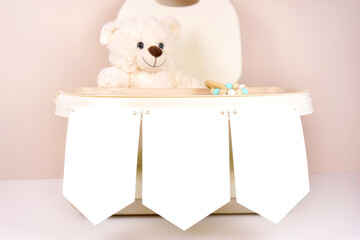 Highchair with 5x7 banner garland mockup. Baby shower 1st birthday christening gender neutral party. Styled setting with white teddy bear against a beige and white background. Negative copy space.