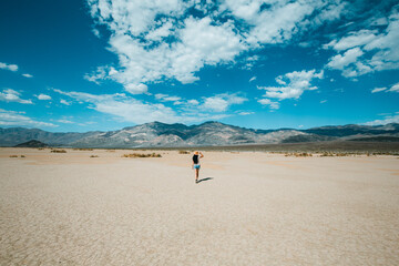 Touristic woman enjoying scenic view on Panamint Valley in Death Valley National Park, California, USA. Walk in Mojave desert with Amargosa Mountain Range in back.