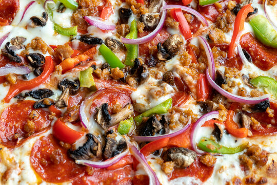 detail of pizza with vegetables, black olives, onion, focus on the upper part of the image