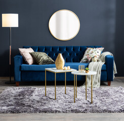 modern velvet sofa in a stylish living room with large round mirror and blue