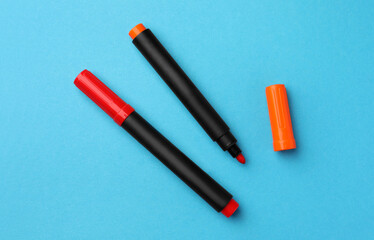 Bright color markers on light blue background, flat lay