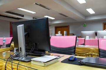 Computer and monitor in room before the seminar, empty seminar room, education