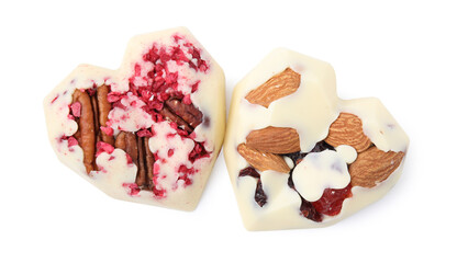 Tasty chocolate heart shaped candies with nuts on white background, top view