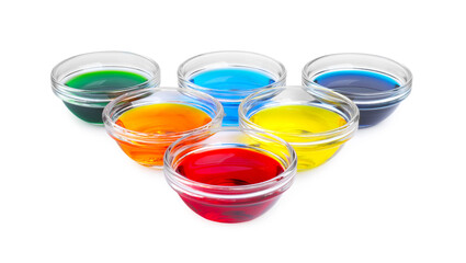 Glass bowls with different food coloring on white background