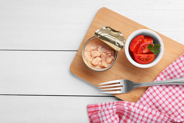 Can of conserved tuna and tomatoes on white wooden table, top view. Space for text
