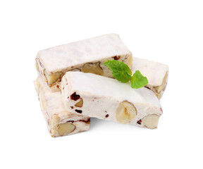 Pieces of delicious nougat and mint on white background