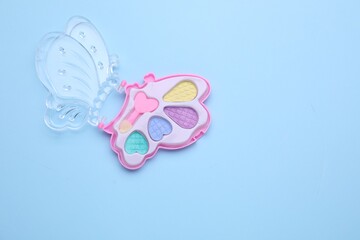 Decorative cosmetics for kids. Eye shadow palette on light blue background, top view. Space for text