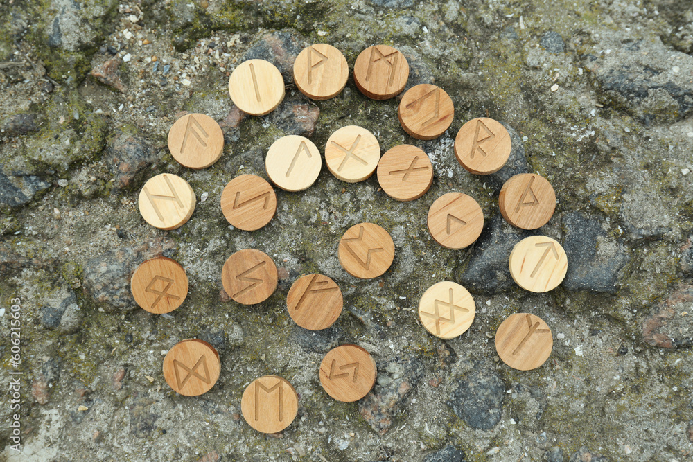 Wall mural many wooden runes on stone outdoors, flat lay